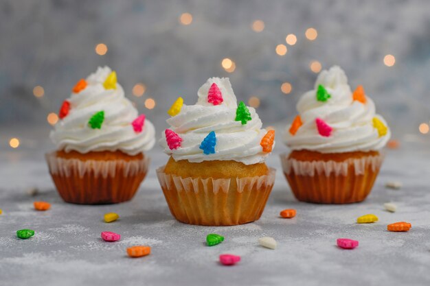 Weihnachtskleiner kuchen mit Weihnachtsbaum formte Wunderkerze und Lichter an