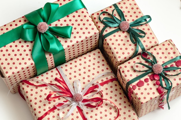 Weihnachtskomposition aus verschiedenen Geschenkboxen, die in Bastelpapier eingewickelt und mit Satinbändern verziert sind. Draufsicht, flach liegen.