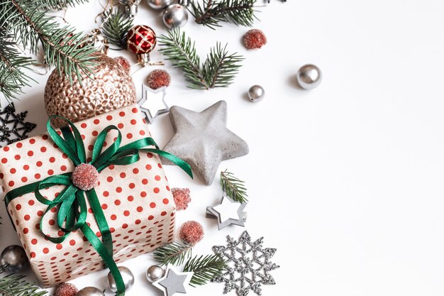 Weihnachtskomposition. Geschenke, Tannenzweige, rote Verzierungen an weißer Wand. Winter, Neujahrskonzept. Flach gelegt, isometrisch, Platz für Text