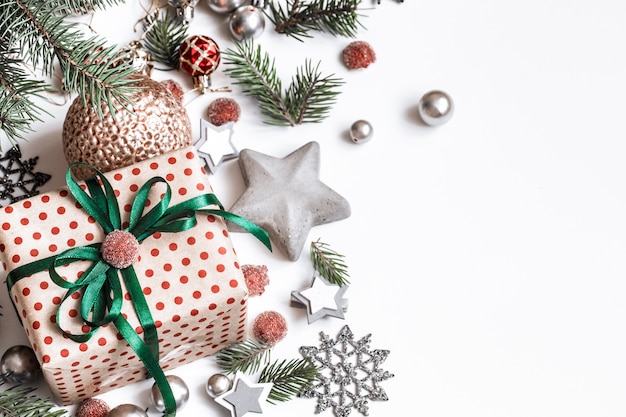 Weihnachtskomposition. Geschenke, Tannenzweige, rote Verzierungen an weißer Wand. Winter, Neujahrskonzept. Flach gelegt, isometrisch, Platz für Text