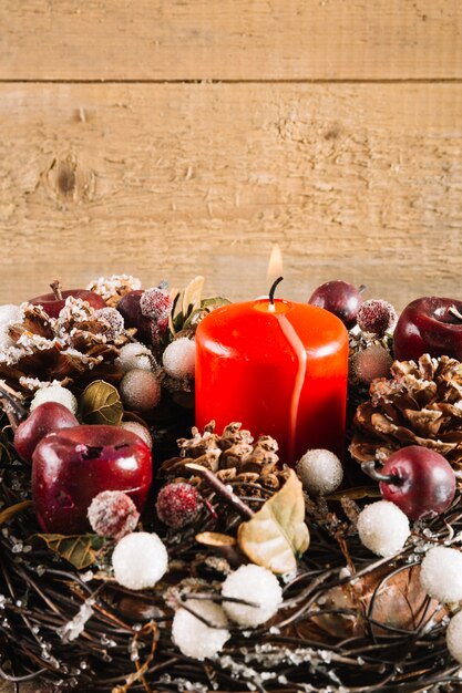 Weihnachtskomposition mit roter brennender Kerze