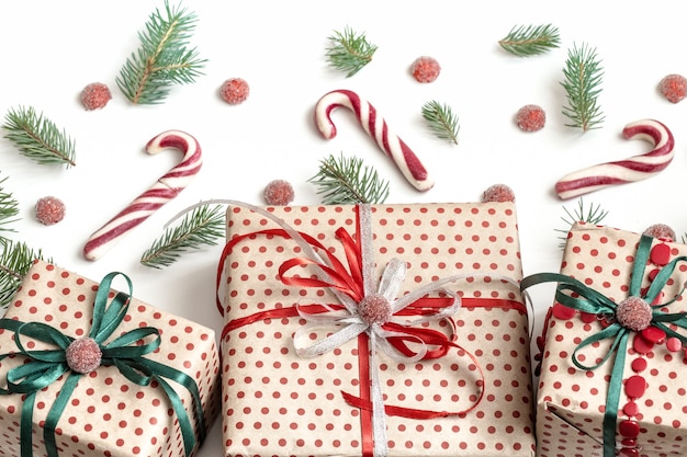 Weihnachtskomposition verschiedener Geschenkboxen, in Bastelpapier eingewickelt und mit Satinbändern verziert. Draufsicht, flach liegen. Weiße Wand.
