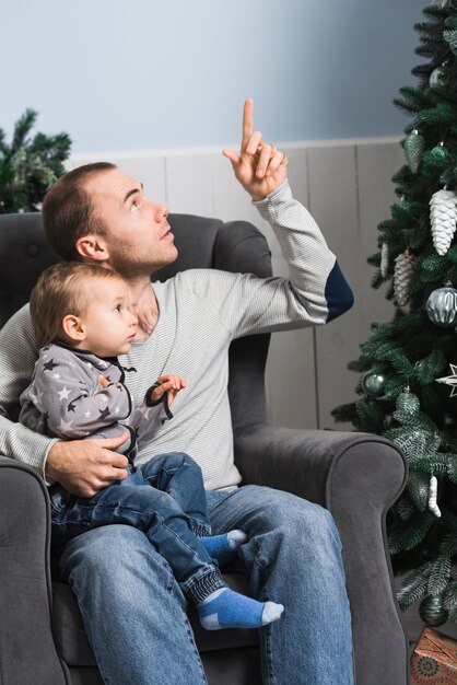 Kostenloses Foto weihnachtskonzept mit dem vater, der oben zeigt