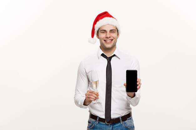 Weihnachtskonzept Schöner Geschäftsmann, der am Telefon spricht und ein Glas Champagner hält, das Chirstmas und Neujahr feiert