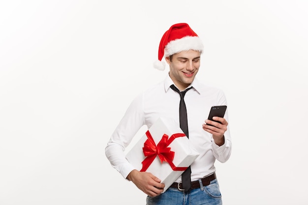 Weihnachtskonzept Schöner Geschäftsmann, der am Telefon spricht und ein Glas Champagner hält, das Chirstmas und Neujahr feiert