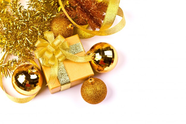 Weihnachtskugeln und ein Geschenk der goldenen Farbe
