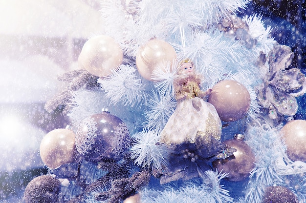 Weihnachtskugeln und eine Puppe, die auf einem Baum