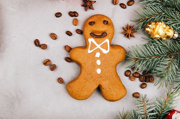 Kostenloses Foto weihnachtslebkuchen, kaffeebohnen, tannenzweig und präsentkarton auf grauem boden