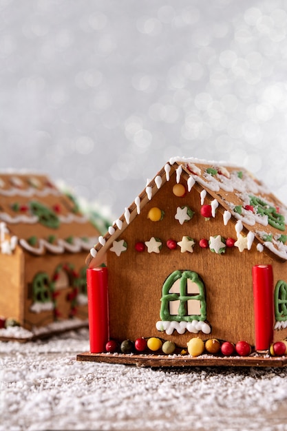 Weihnachtslebkuchenhaus auf weißem Glitzerhintergrund