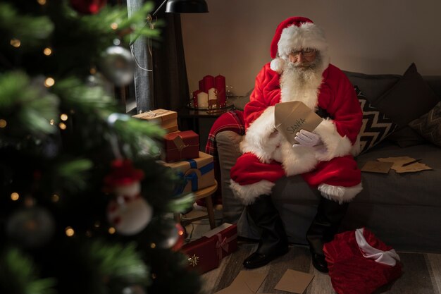 Weihnachtsmann, der einen Brief von einem Kind öffnet