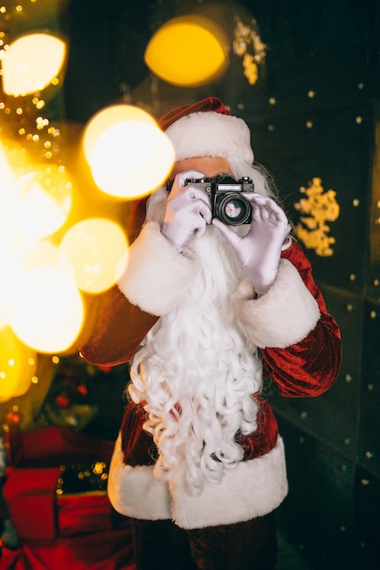 Kostenloses Foto weihnachtsmann, der fotos auf kamera macht