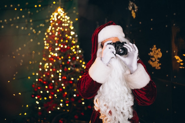 Kostenloses Foto weihnachtsmann, der fotos auf kamera macht