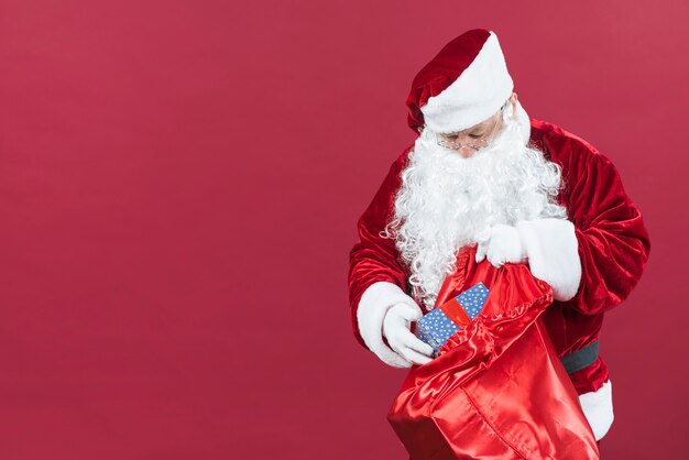Weihnachtsmann, der Geschenkkasten vom Sack erhält