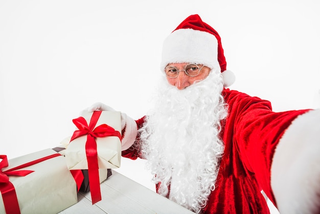 Weihnachtsmann, der selfie mit Geschenkboxen nimmt