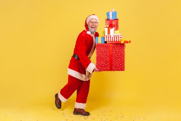 Weihnachtsmann, der stapel weihnachtsgeschenkboxen hält und weihnachtsfeiertage feiert.