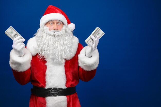 Weihnachtsmann hält geld auf farbigem hintergrund