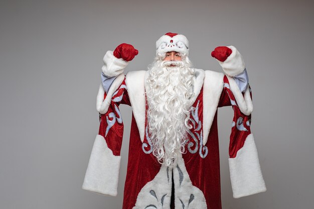 Weihnachtsmann mit erhobenen Händen im roten Kostüm
