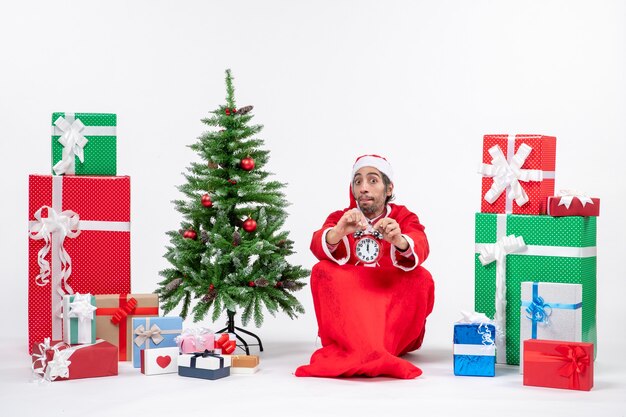 Weihnachtsmann sitzt mit Geschenkboxen und Baum