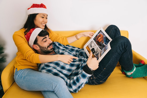 Kostenloses Foto weihnachtspaarlesung auf couch