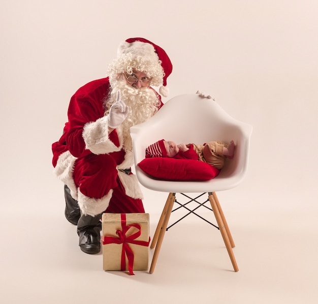 Weihnachtsporträt des niedlichen kleinen neugeborenen Mädchens, gekleidet in Weihnachtskleidung, Studioaufnahme, Winterzeit