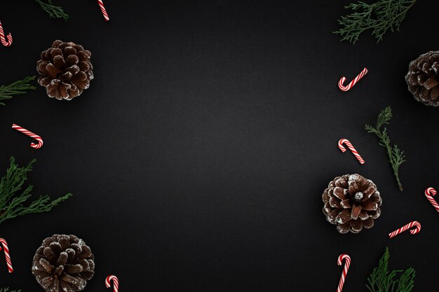Weihnachtsschmuck und Zuckerstangen auf dunklem Hintergrund