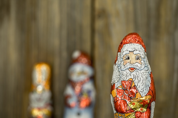Kostenloses Foto weihnachtsschokoladenfiguren in einer hülle auf holz