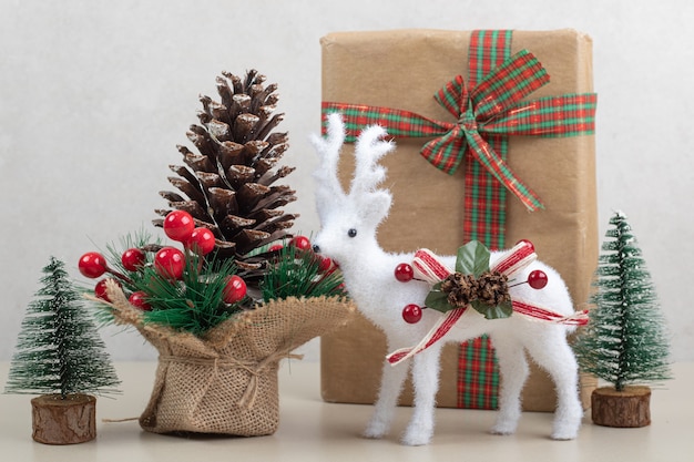 Kostenloses Foto weihnachtsspielzeug mit papierbox und dekoration auf weißer oberfläche