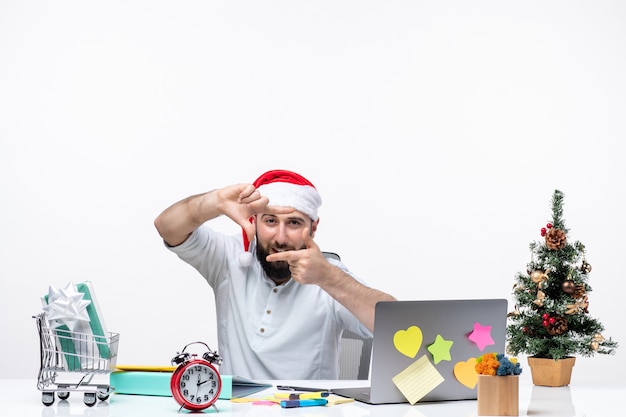 Weihnachtsstimmung mit jungem erwachsenen mit seinem weihnachtsmann, der etwas zeigt und im büro an einem projekt beteiligt ist Kostenlose Fotos