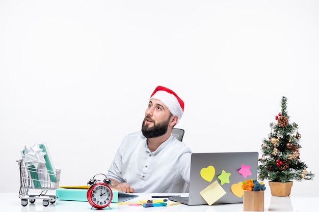 Kostenloses Foto weihnachtsstimmung mit verwirrtem jungen erwachsenen mit weihnachtsmann, der jemanden im büro anhört