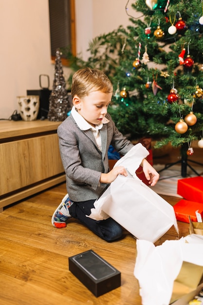 Weihnachtsszene mit dem Jungen, der Geschenke empfängt