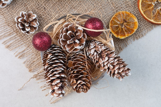 Kostenloses Foto weihnachtstannenzapfen mit getrockneten orangen auf sackleinen. hochwertiges foto