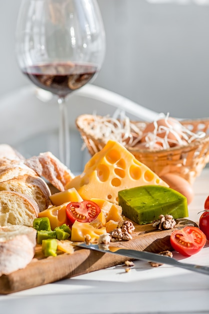 Wein, Baguette und Käse auf Holz