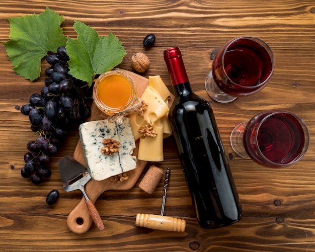 Wein mit Lebensmittel auf hölzernem Hintergrund