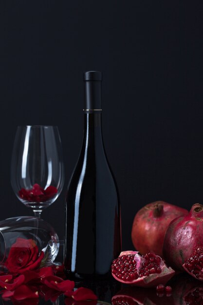 Weinflasche mit Bechern, Granatäpfeln und Rosenblättern