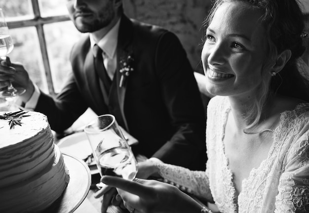 Weingläser der Braut und des Bräutigams Cling mit Freunden auf Hochzeitsempfang