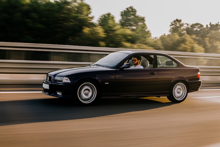 Kostenlose Foto weinleselimousinenautofahren auf der autobahn. seitenansicht.