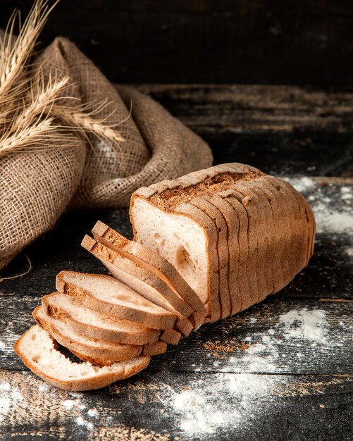 Weißbrot geschnittenes Weißbrot mit Mehl und Weizen auf dem Tisch