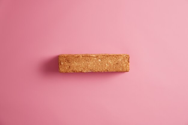 Weißbrot-Toast mit appetitlicher Kruste, die von oben fotografiert wird, lokalisiert über rosigem Hintergrund. Scheibe Getreidebrot. Leckeres leckeres Frühstück. Snack und Essen. Richtiges substanzielles Ernährungskonzept