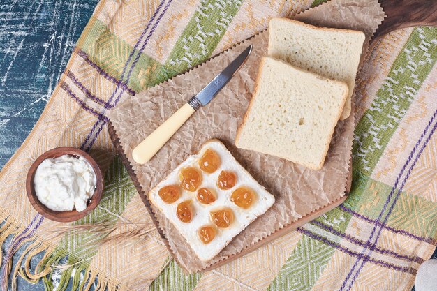 Weißbrotscheiben mit sauerrahm und confiture.