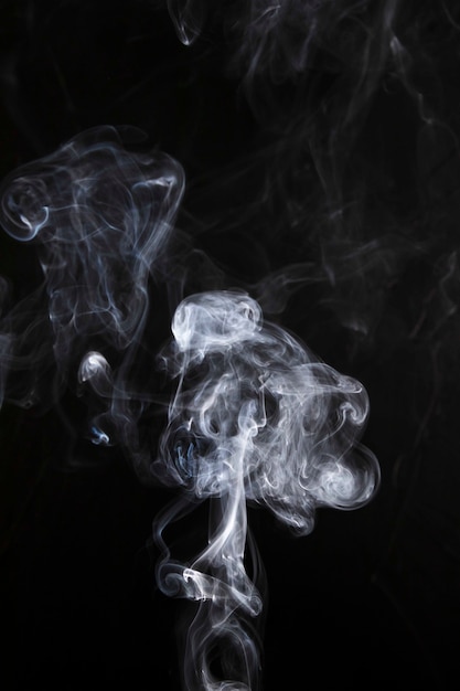 Weiße abstrakte Rauchkurven und -welle auf schwarzem Hintergrund