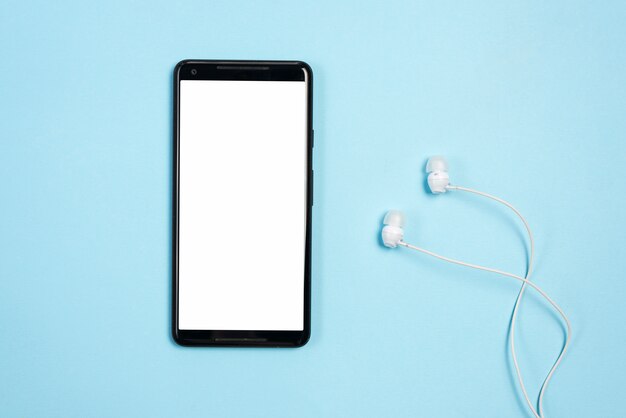 Weiße Anzeige des leeren Bildschirms am Handy mit Kopfhörern gegen blauen Hintergrund
