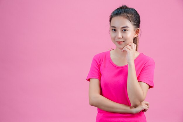 Weiße asiatische Frauen tragen rosa Hemden. Legen Sie seine linke Hand in sein Gesicht auf dem Rosa.