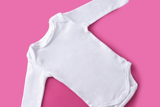 Weiße Babykleidung auf rosa Hintergrund Kopieren Sie Platz