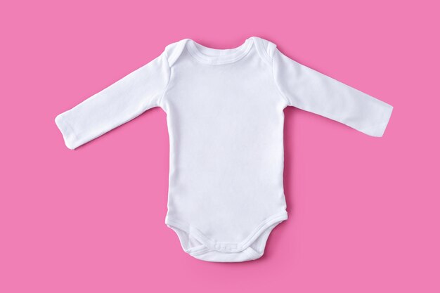 Weiße Babykleidung auf rosa Hintergrund Kopieren Sie Platz