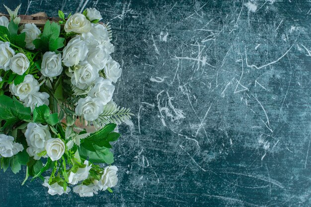 Weiße Blumen in einem Serviettenhalter auf blauem Hintergrund.