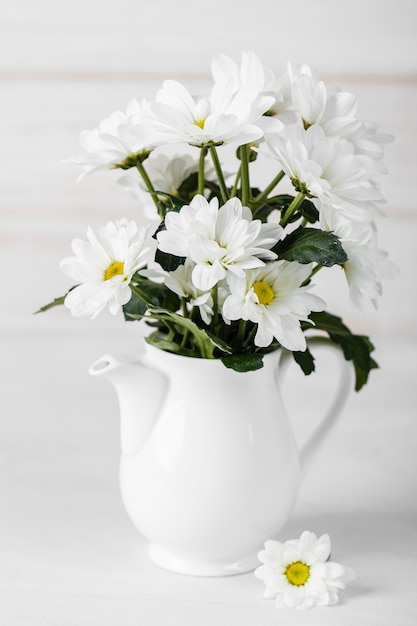 Weiße Blumenanordnung in der weißen Vase