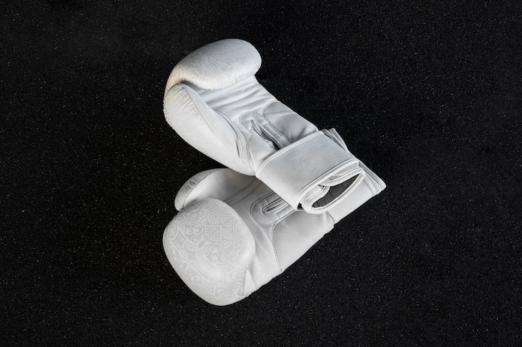 Kostenlose Foto weiße boxhandschuhe mit dunklem hintergrund