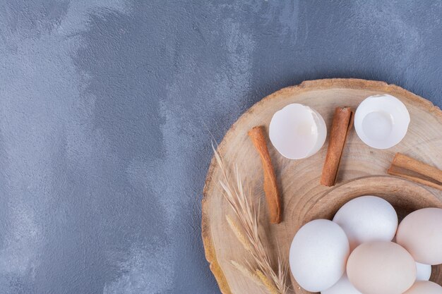 Weiße Eier und Eierschalen auf einer Holzplatte.