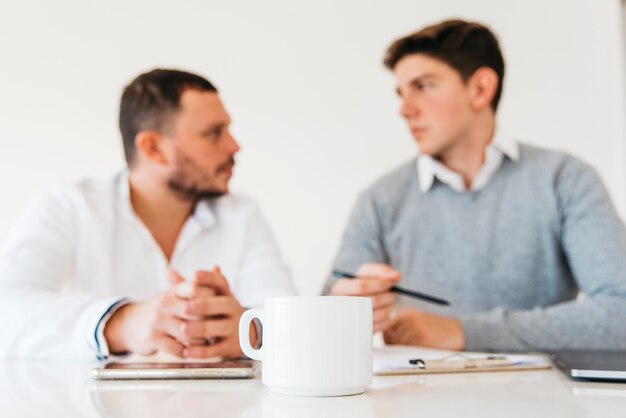 Weiße Kaffeetasse auf Bürotisch