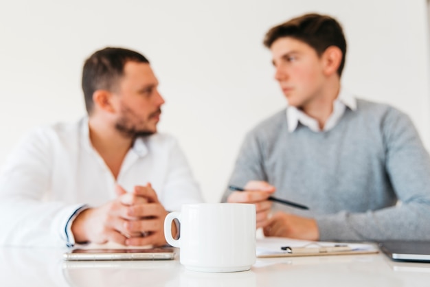 Weiße Kaffeetasse auf Bürotisch